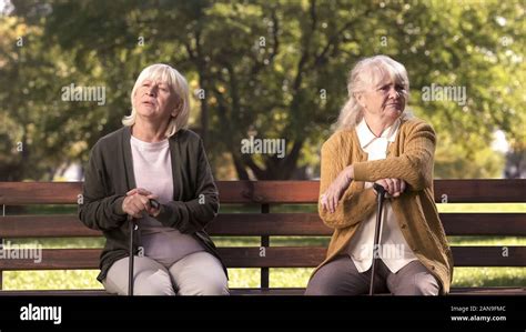 Mature Ladies Sitting Separately On Bench In Park Friends Argued And