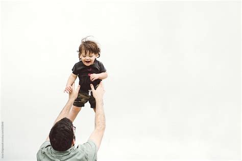 Father Throwing Son In The Air Outside By Stocksy Contributor Kate