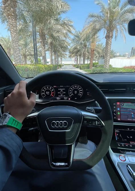 A Man Driving An Audi Car With Palm Trees In The Background