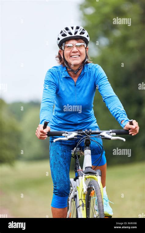 Active Senior Woman Trains Her Fitness While Riding A Mountain Bike Stock Photo Alamy