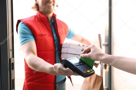 A customer can leave an optional tip Woman paying for food delivery with credit card at door ...