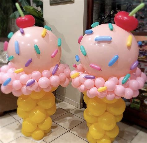 Two Giant Balloons With Sprinkles And Cherry On Top Are Shown In Front
