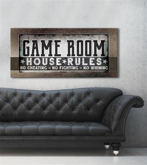 A Black Leather Couch In Front Of A Gray Wall With A Game Room Sign