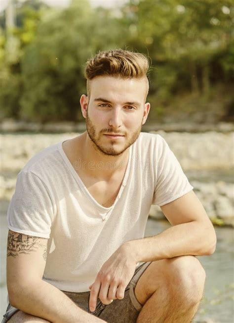 Portrait Of Handsome Young Man In White T Shirt In Nature Stock Photo