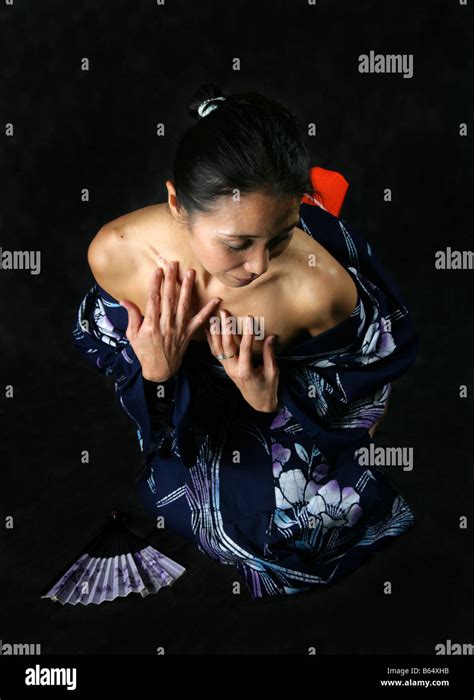 Japanese Woman In A Blue Kimono Kneeling In A Submissive Position