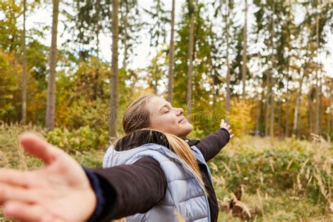 Woman With Outstretched Arms Doing Breathing Exercise In Forest Stock