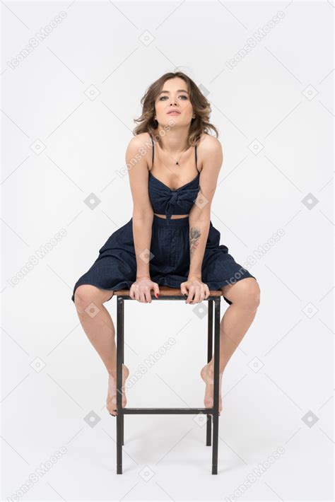 Фото Чувственная женщина сидит на стуле в баре с широко расставленными ногами