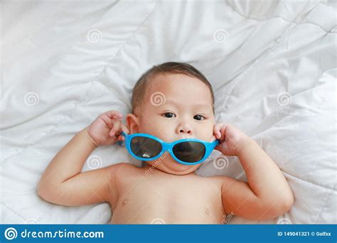 Portrait Little Asian Baby Boy With Sunglasses Lying On White Blanket