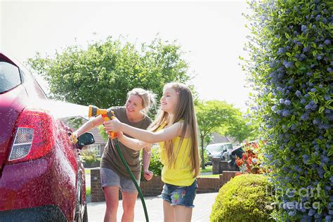 Mother And Daughter Washing Car In Sunny Driveway Photograph By Caia Imagescience Photo Library