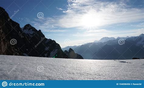 The Sun Shines Brightly View Of Snowy Mountains Blue Sky Cliff And
