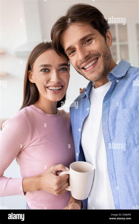 Portrait Of Cheerful Smiling Young Wife And Husband With Cup Of Hot Drink Taking Photo On