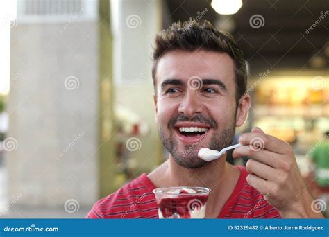 Handsome Man Eating Cereal At Breakfast Table With Open Blue Shirt Revealing Defined Chest And