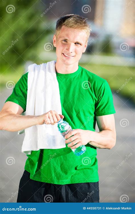 Tired Man With White Towel Drinking Water From A Plastic Bottle Stock