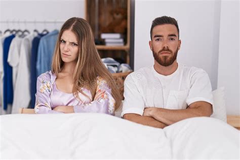 Man And Woman Couple Sitting On Bed Arguing At Bedroom Stock Image