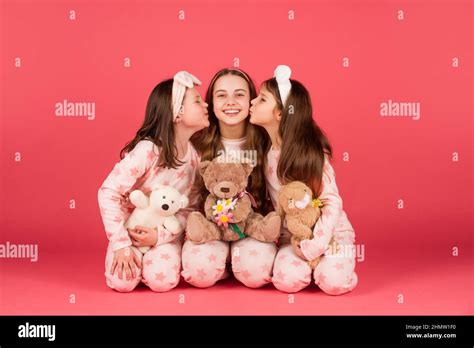 Happy Girls In Pyjamas Kissing Elder Sister Sitting Together With Teddy Bears Sisterly Love