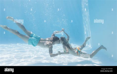 Cute Couple Holding Hands Underwater In The Swimming Pool Stock Photo