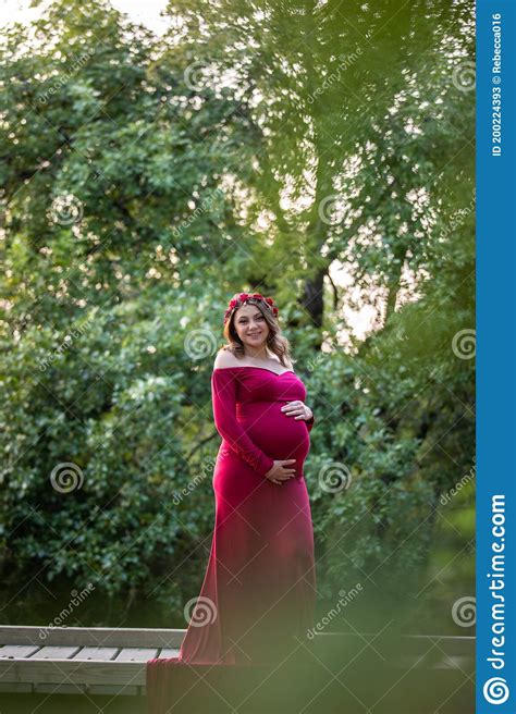 Pretty Young Expecting First Time Mother Standing In Beautiful Red