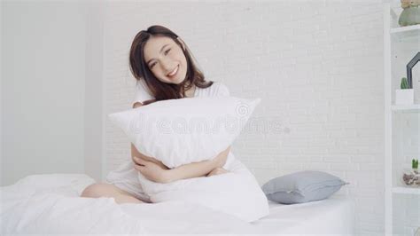 Happy Beautiful Asian Woman Wake Up Smiling And Stretching Her Arms In