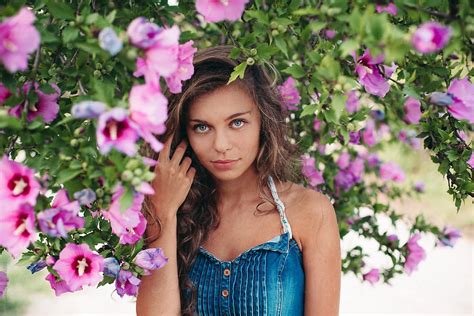 Spring Portrait Of Beautiful Girl Around Purple Flowers Bush By