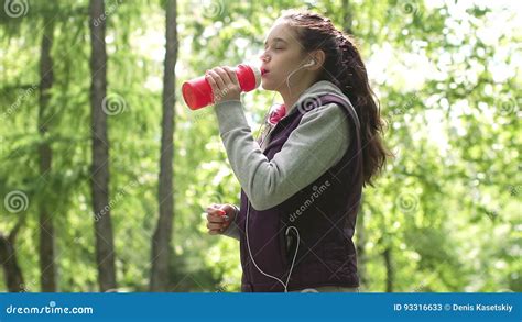 Young Sporty Girl Is Drinking Water In Training Sportsman On A Run In