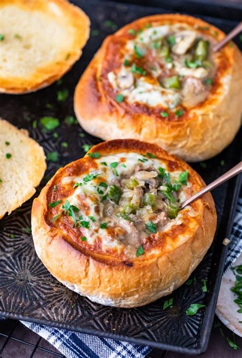 Bread Bowls Filled With Philly Cheese Steak Soup Topped With Cheese