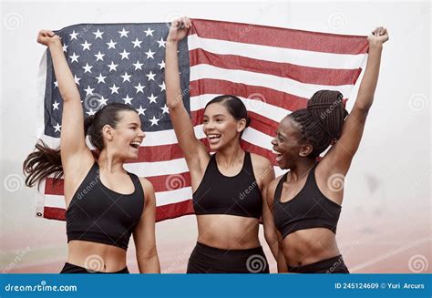 We Finally Did It Shot Of Female Athletes Celebrating Their Win While Holding A Flag Stock