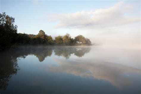 Mist Over A Tranquil Lake Photograph By John Doornkamp Design Pics