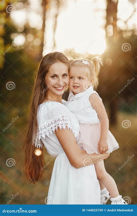 A Woman Holds A Child In Her Arms In The Park Stock Image Image Of