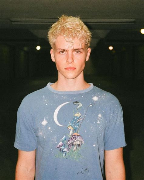 A Young Man With Blonde Hair Wearing A Blue T Shirt