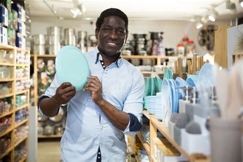 Cheerful Man Showing Plate Bought At Household Goods Store Stock Photo