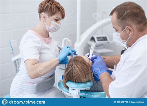 Doctor Dentist Treats Teeth Of A Beautiful Young Girl Patient The Girl