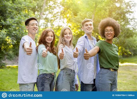 Group Of Multiethnic Teen Friends Standing Outdoors Showing Thumbs Up