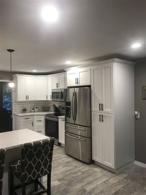 A stylish black and white kitchen by sara ray interior design combines open shelving with black shaker base cabinets. White shaker cabinets with solid surface countertops and ...