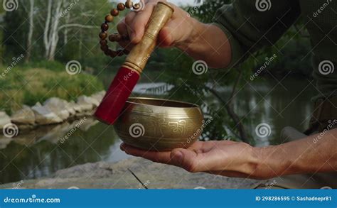 Close Up A Man Extracting Sound From A Singing Tibetan Bowl While