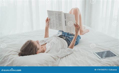Young Beautiful Caucasian Woman Reading On The Book While Laying Down On The Bed Stock Image