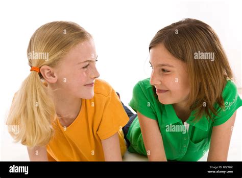 Two Girls Lying On The Floor Smiling At Each Other Stock Photo Alamy