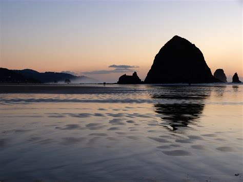 Silhouette Of Large Rocks Rising Out Of The Ocean At Dusk In Oregon