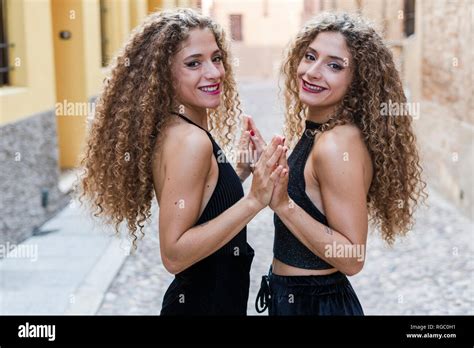 Portrait Of Happy Twin Sisters Touching Their Hands Stock Photo Alamy