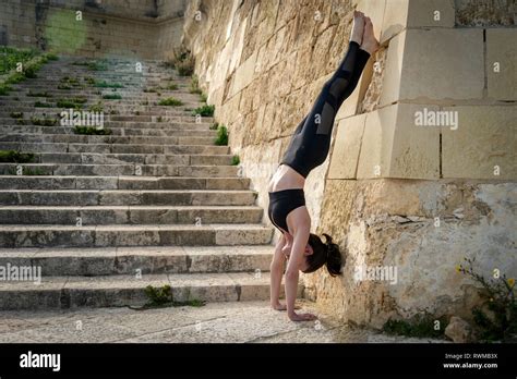 Woman Doing A Handstand Against A Wall Outside Stock Photo Alamy