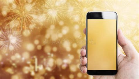 Hand Holding Mobile Smart Phone Luxury Gold Bokeh Light With Fireworks