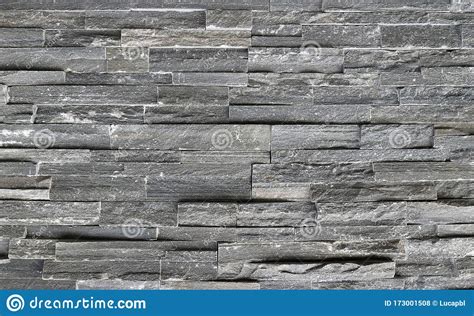 Stone Cladding Wall Made Of Striped Stacked Slabs Of Natural Dark Gray