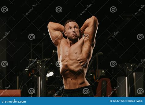 A Bodybuilder With A Beard Is Doing A Stomach Vacuum Pose During A