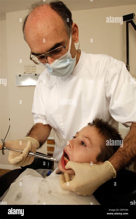 Un Dentista Inyecta Anestesia En La Encía De Un Paciente Joven