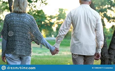 Old Couple Holding Hands And Walking In Park Romantic