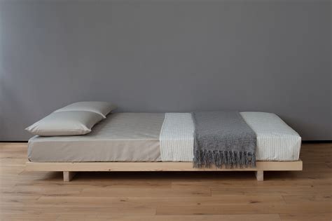 A Bed Sitting On Top Of A Wooden Floor Next To A Window