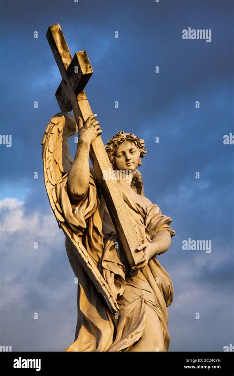 Figure Of Sad Angel Carries Heavy Cross In The Evening Light Stock
