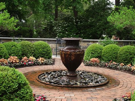 Iron Fountain Urn On River Rock Covered Below Grade Basin Surrounded