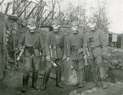 Four Heavily Armed German Soldiers Wearing Gas Masks And An Early Type