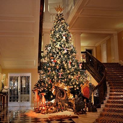 A Decorated Christmas Tree In The Middle Of A Room With Stairs And
