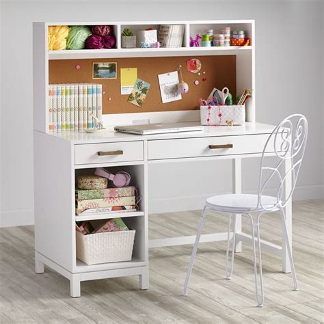 A White Desk And Chair With Craft Supplies On The Top Shelf In Front